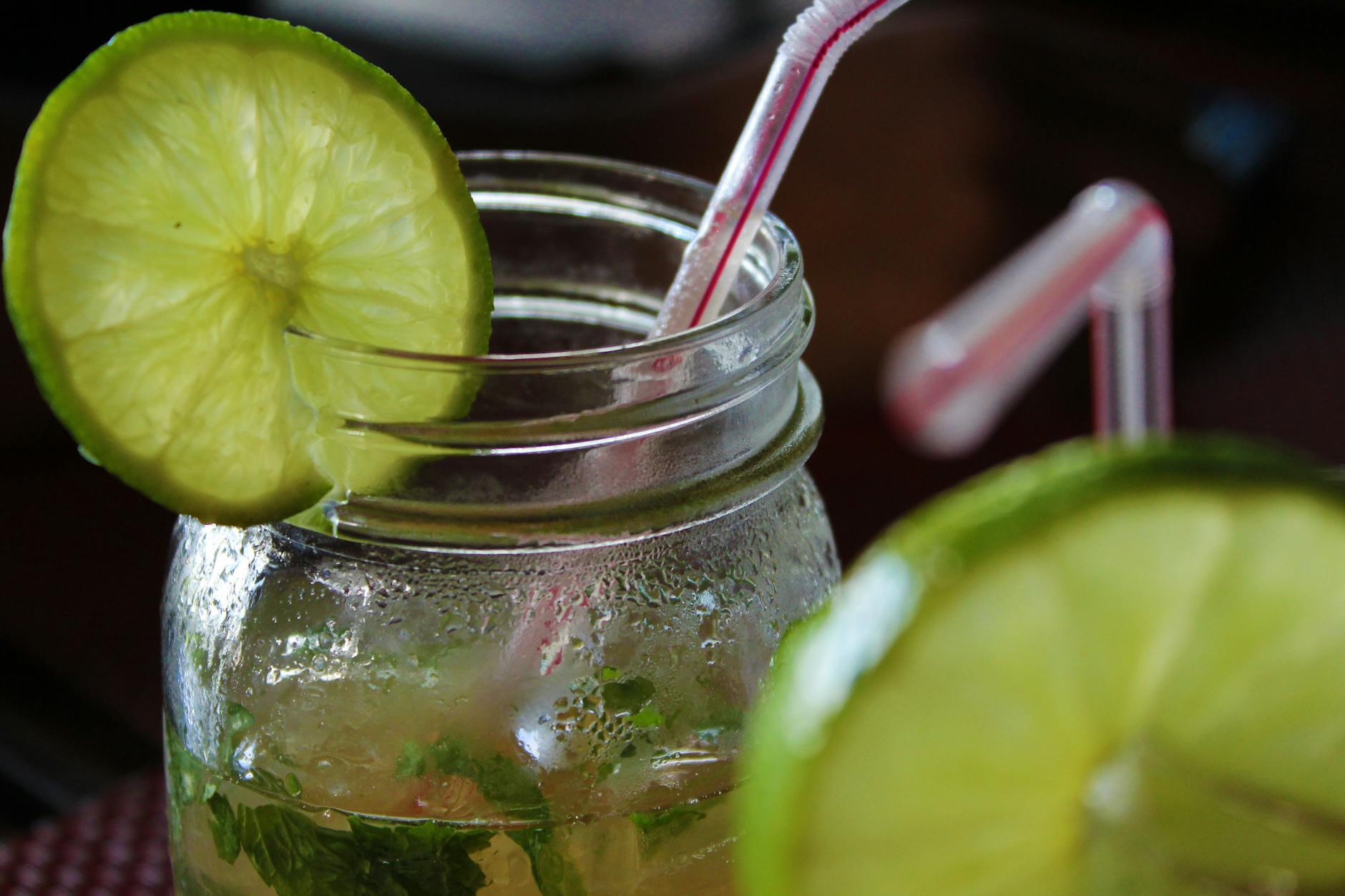Zbliżenie na orzeźwiające mojito z limonką i słomką