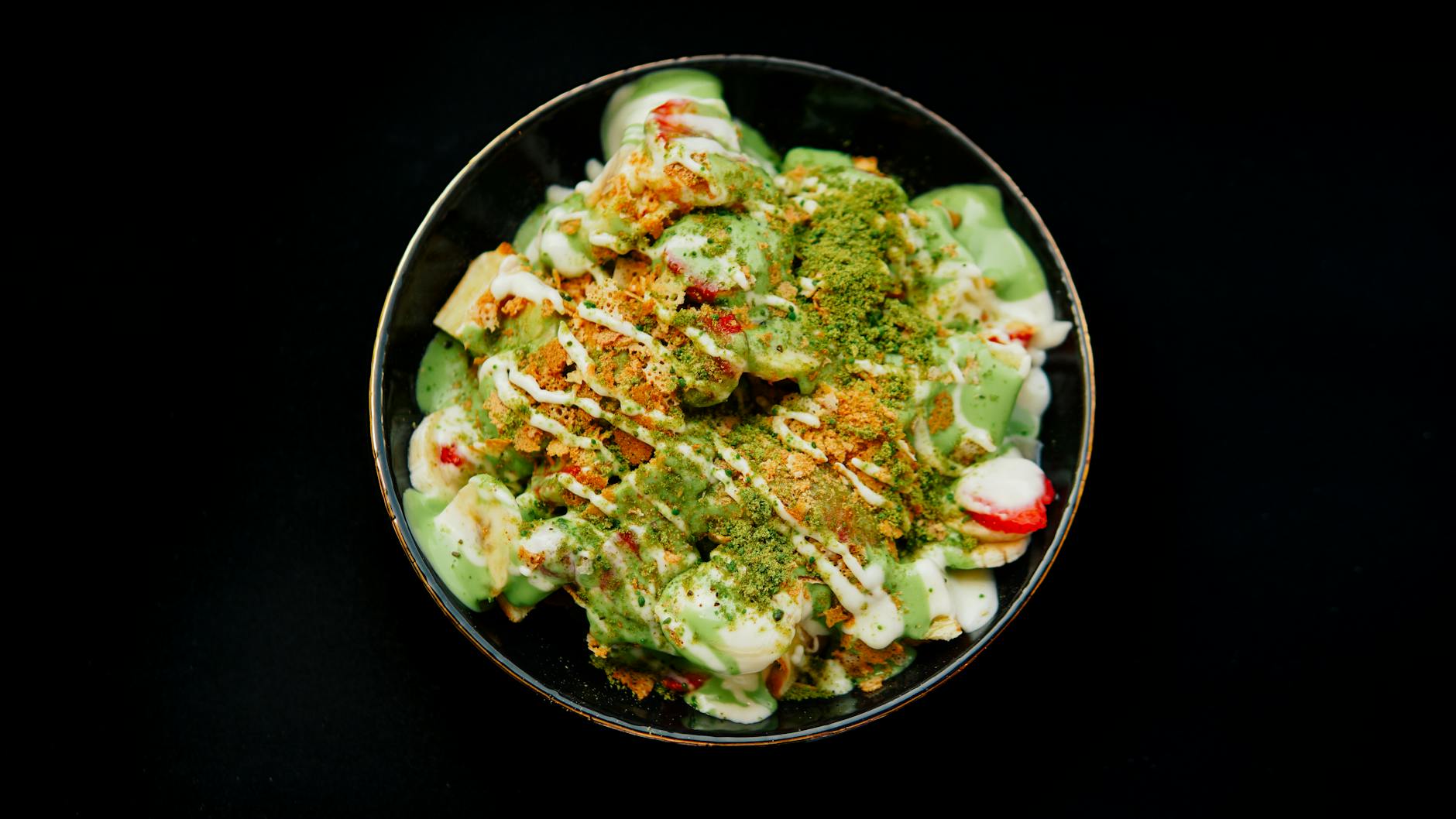 Miska deseru z matchą, świeżymi owocami i zielonym słodkim sosem