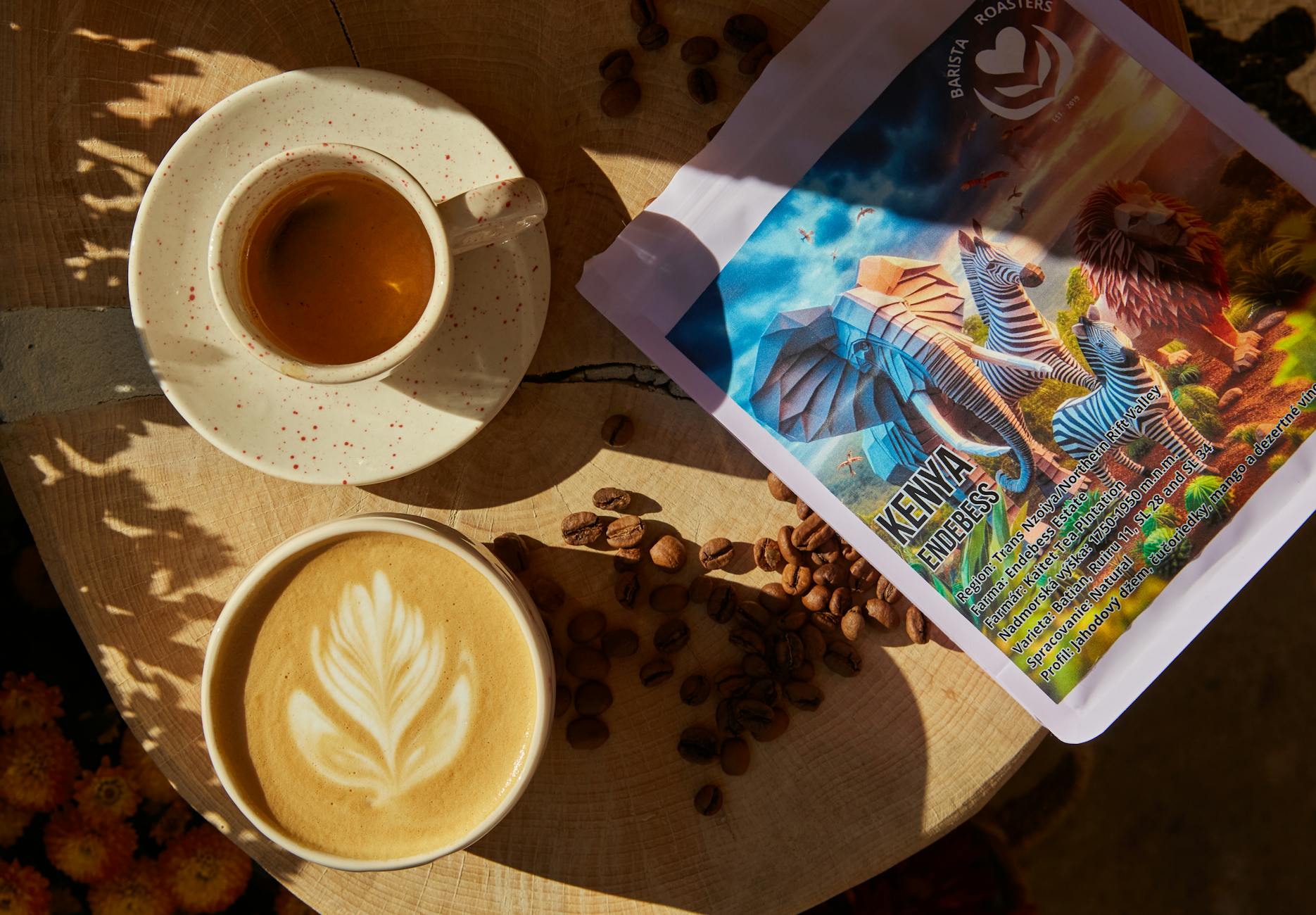 Płaskie ujęcie kawy z latte art, ziaren i opakowania w domowej kawiarni