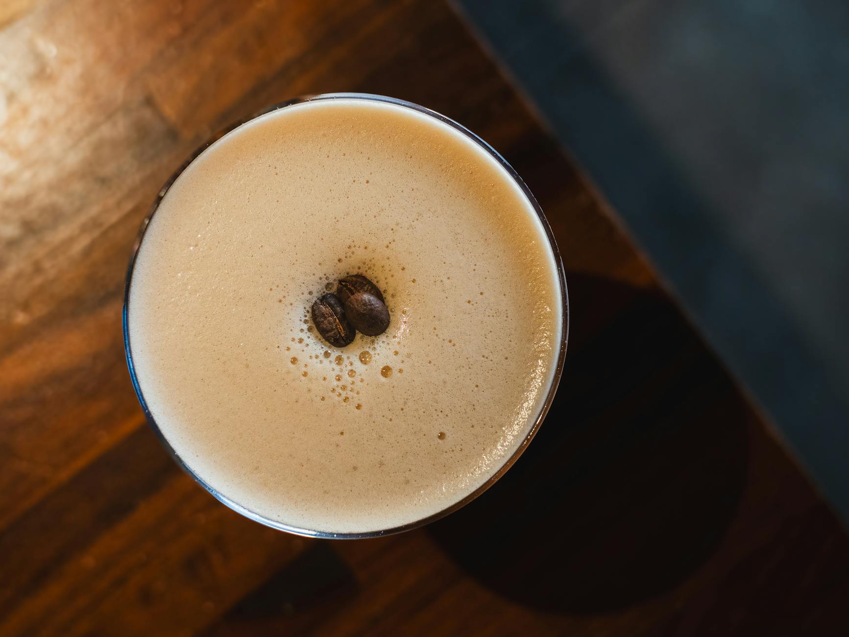 Bezalcoholowy espresso martini z pianką i ziarnami kawy z lotu ptaka