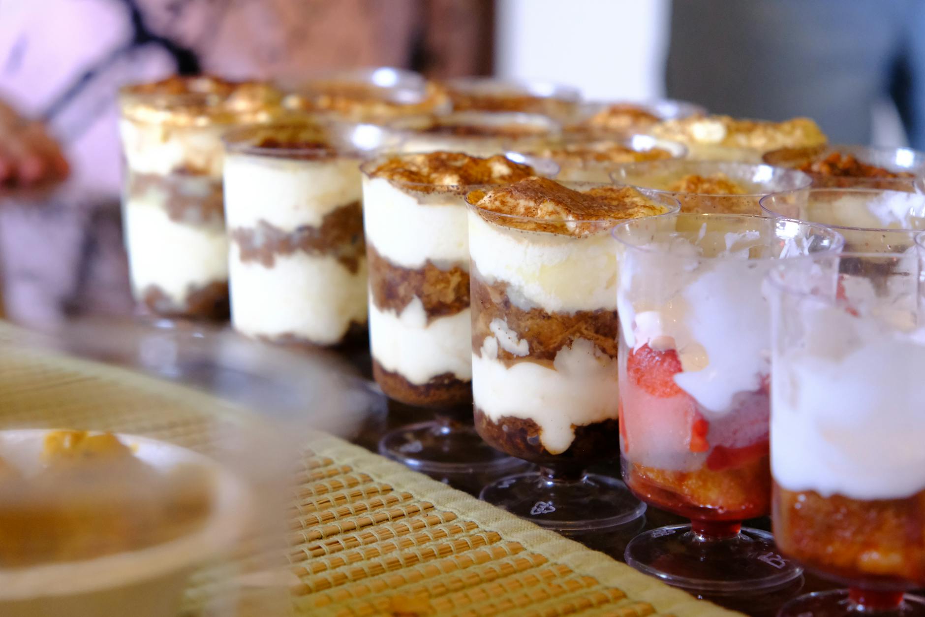 Pucharki z tiramisu i owocowymi deserami warstwowymi na stole