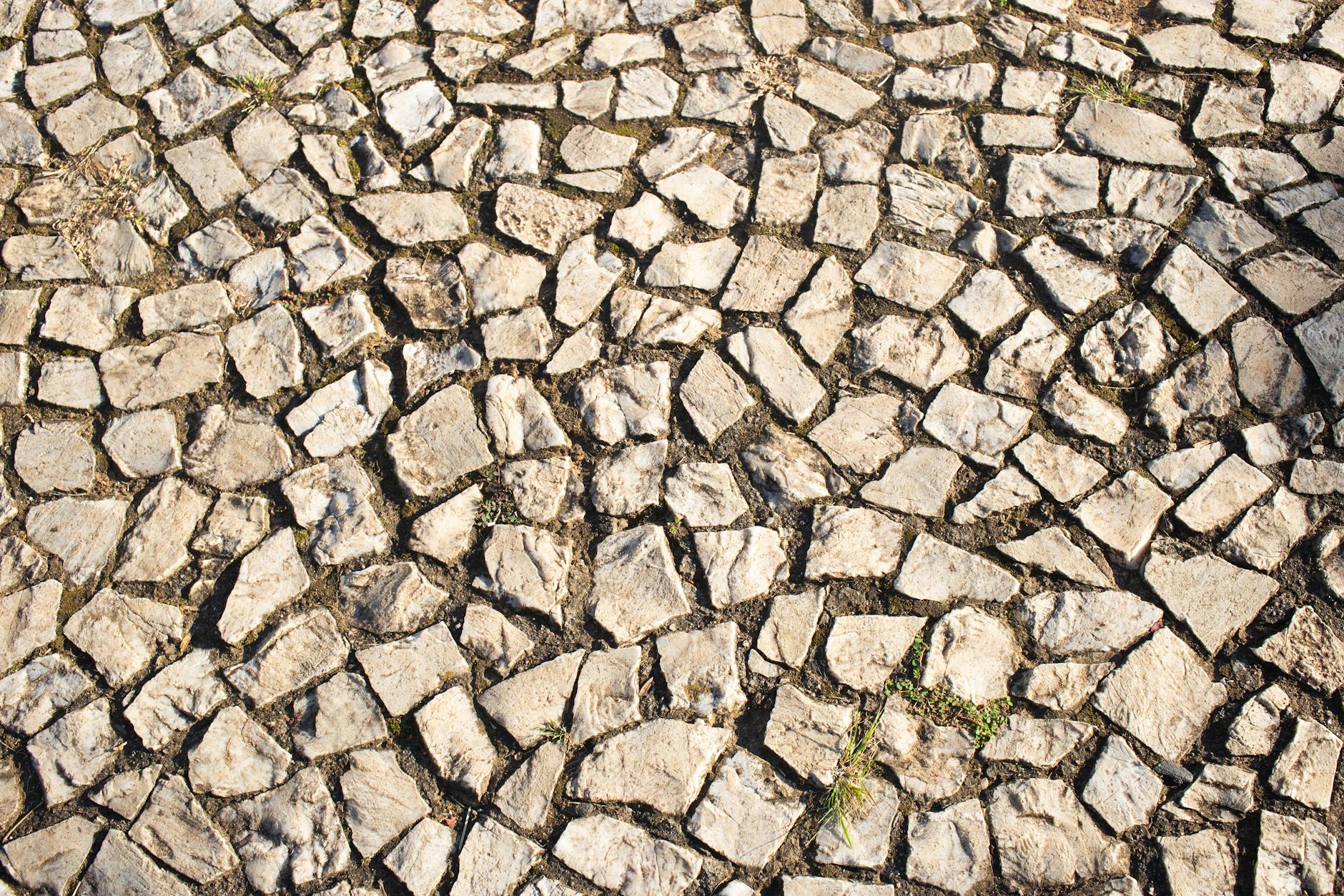 Zbliżenie na kostkę brukową o naturalnej fakturze i mozaikowym wzorze