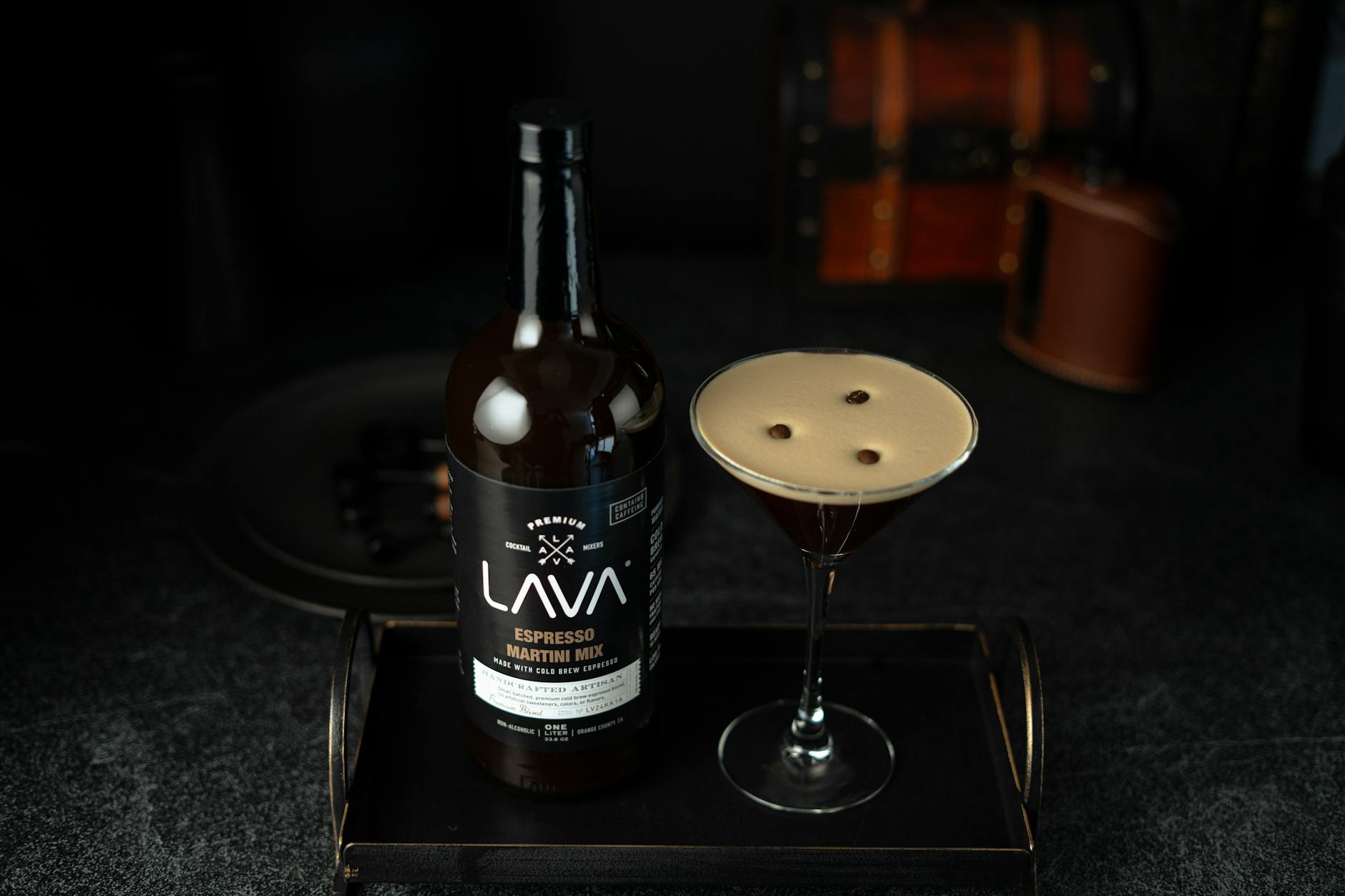 Espresso martini w kieliszku i butelka mikstury na tacy