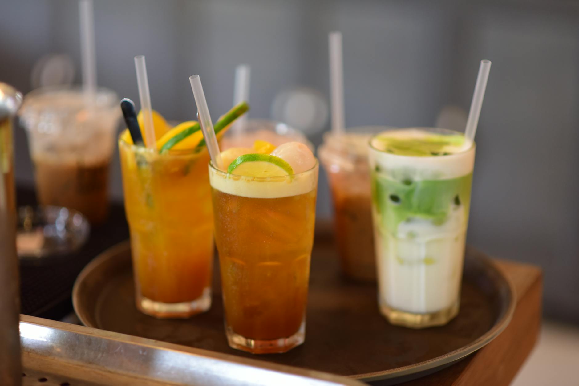 Taca z mrożoną herbatą i matcha latte podana w szklankach