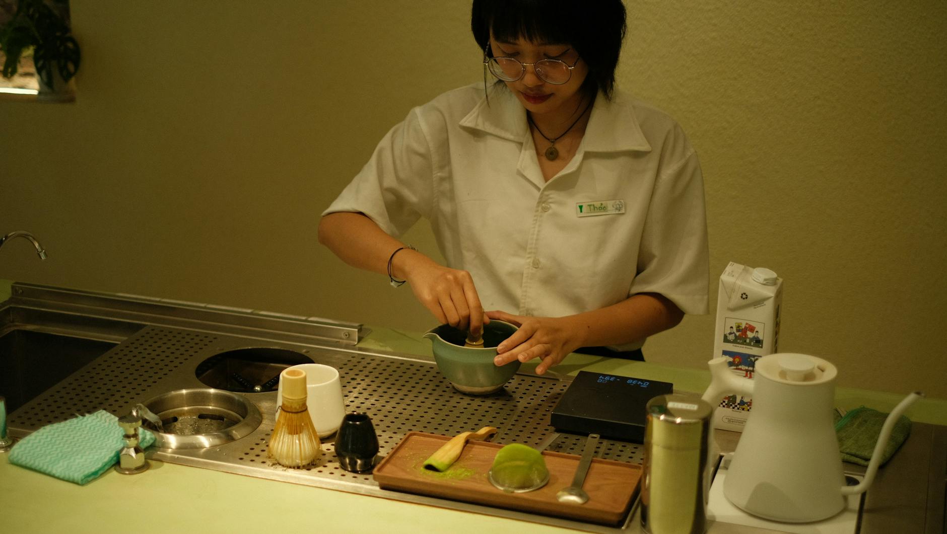 Barista przygotowuje herbatę matcha w nowoczesnej herbaciarni
