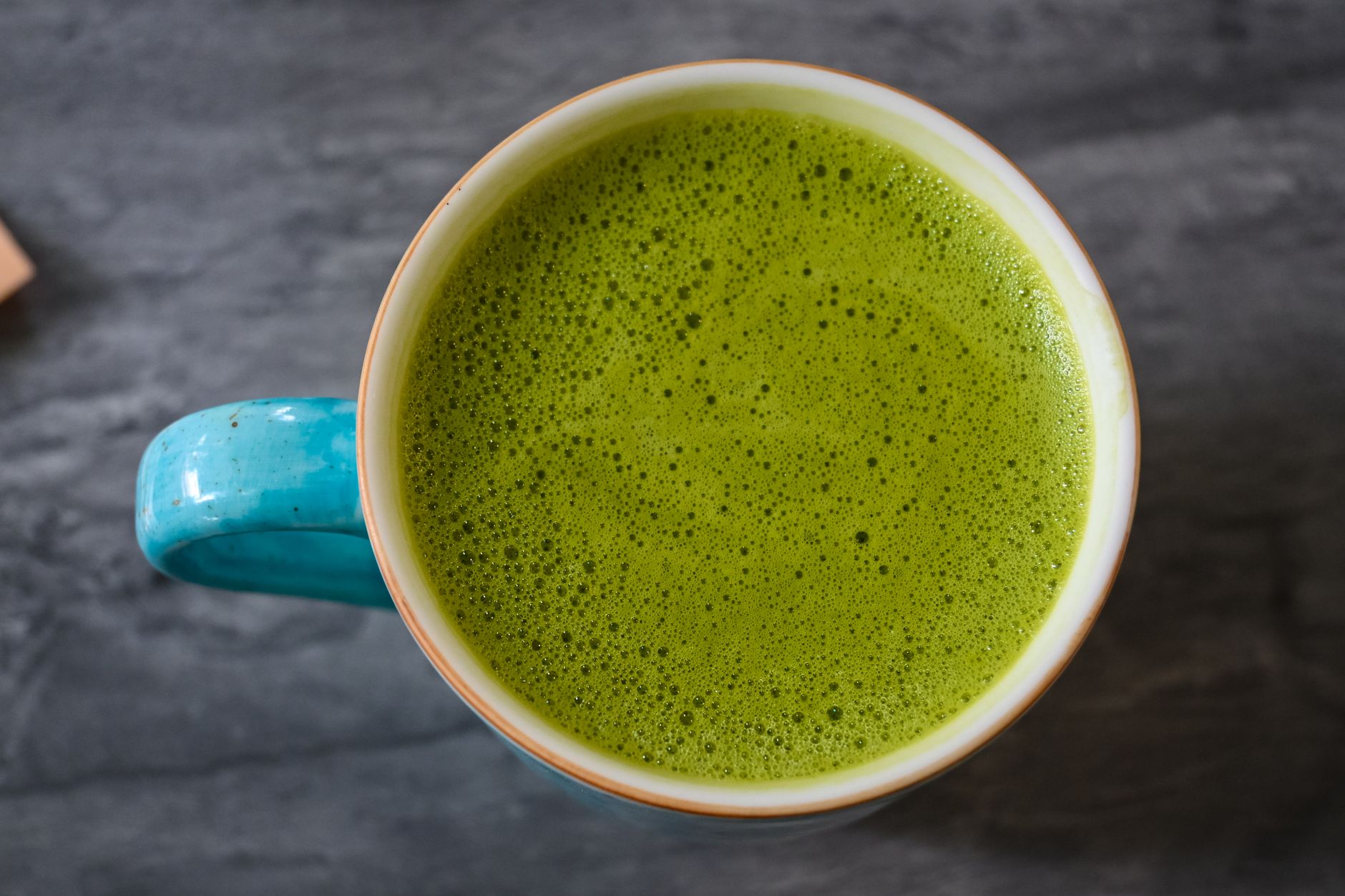 Ceramiczna filiżanka z pienistą zieloną herbatą matcha z góry