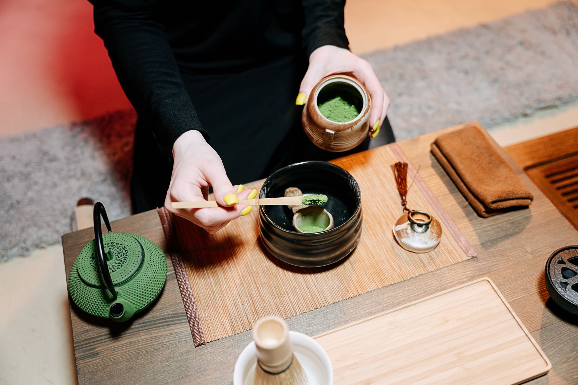 Dłonie przygotowujące herbatę matcha w tradycyjny japoński sposób