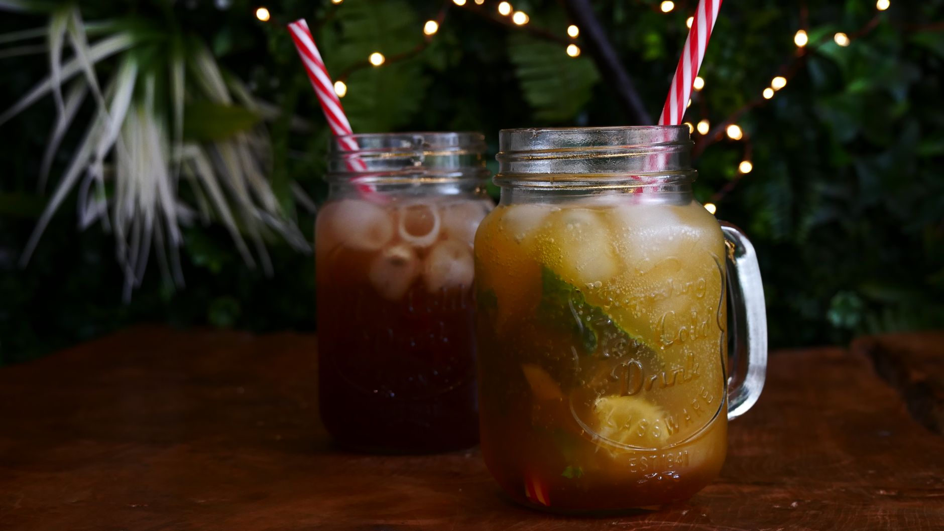 Dwie szklanki cold brew tea w słoikach na drewnianym stole na zewnątrz