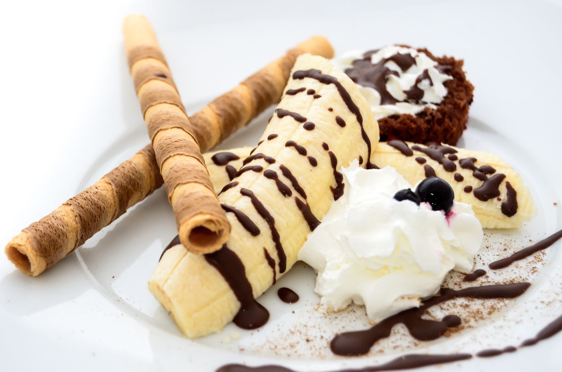 Zbliżenie na lody bananowe z polewą czekoladową i bitą śmietaną