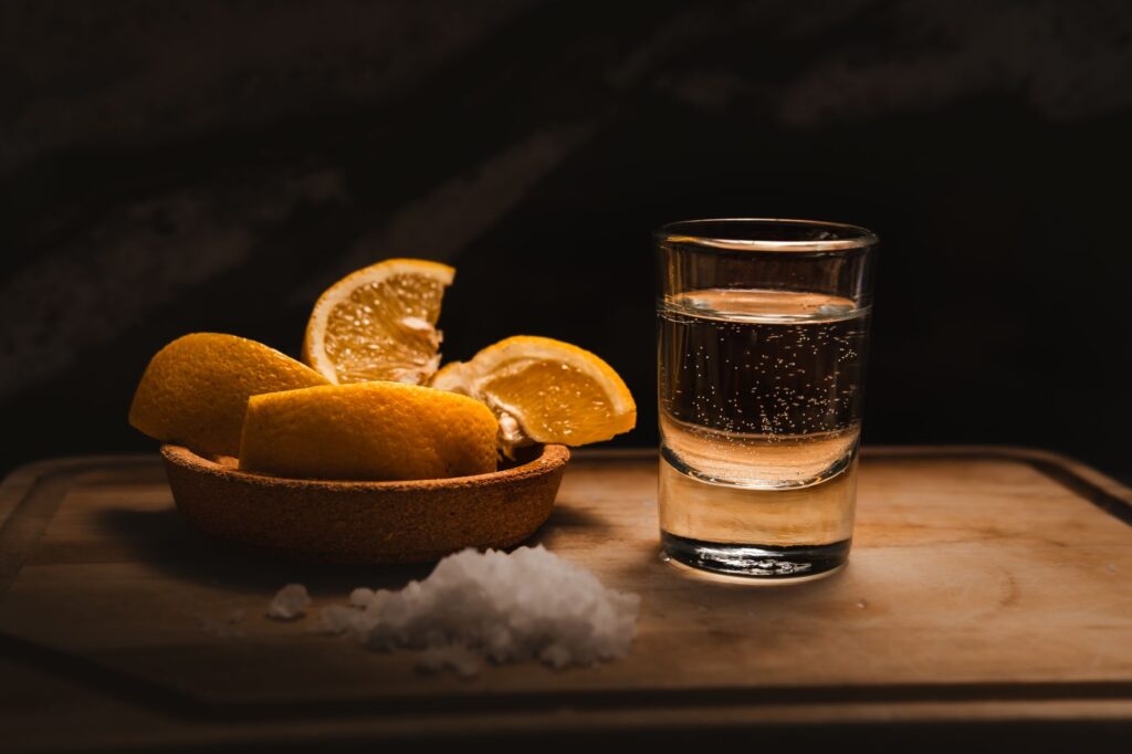 Kieliszek tequili z plasterkami cytryny i solą na barze
