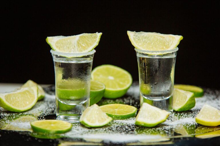 Kieliszki tequili z limonką i solą na stole