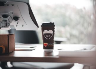 Przekąski do kawy w pracy: co zabrać do biura bez okruszków i chłodzenia Kubek kawy McCafé na nowoczesnym biurku w pracy
